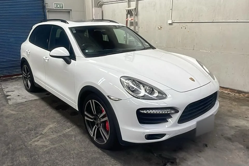 White Porsche SUV photographed from the front and side